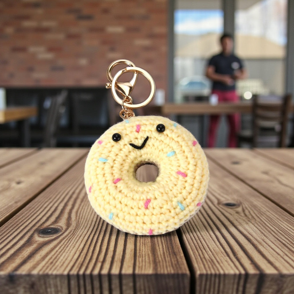 Crocheted donut keychain with sprinkles on a wooden table