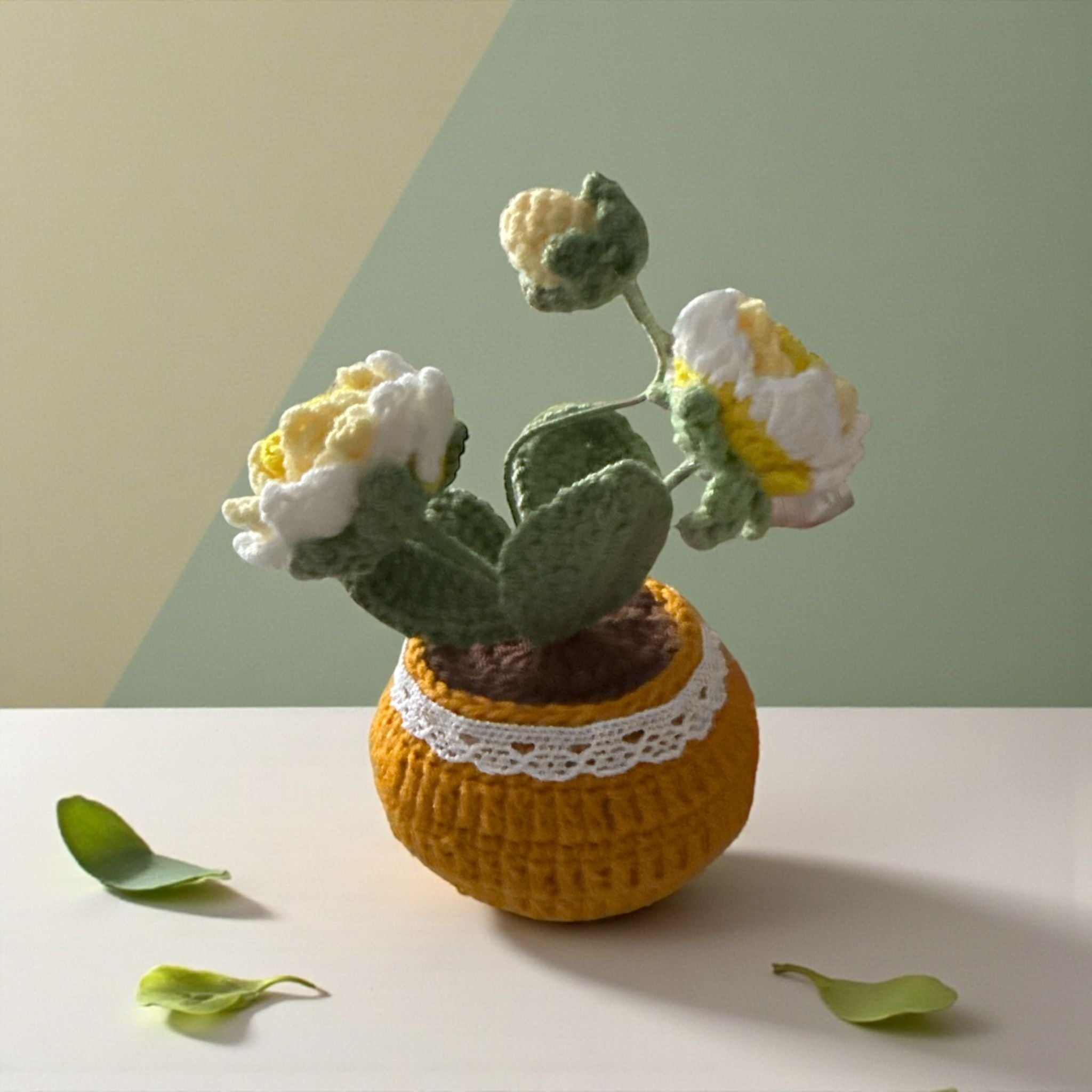 Knitted potted plant with flowers on a neutral background