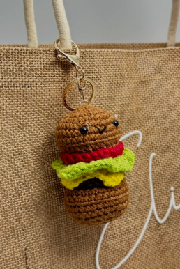 Crocheted hamburger keychain on a textured bag