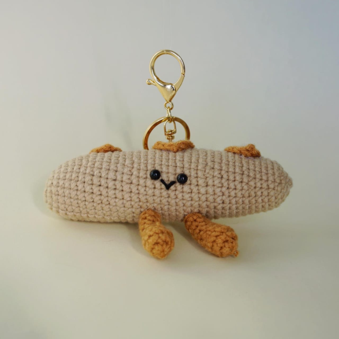 Crocheted keychain with a face on a light background