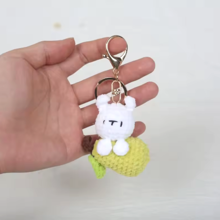 Keychain with a cartoon character held in a hand against a white background