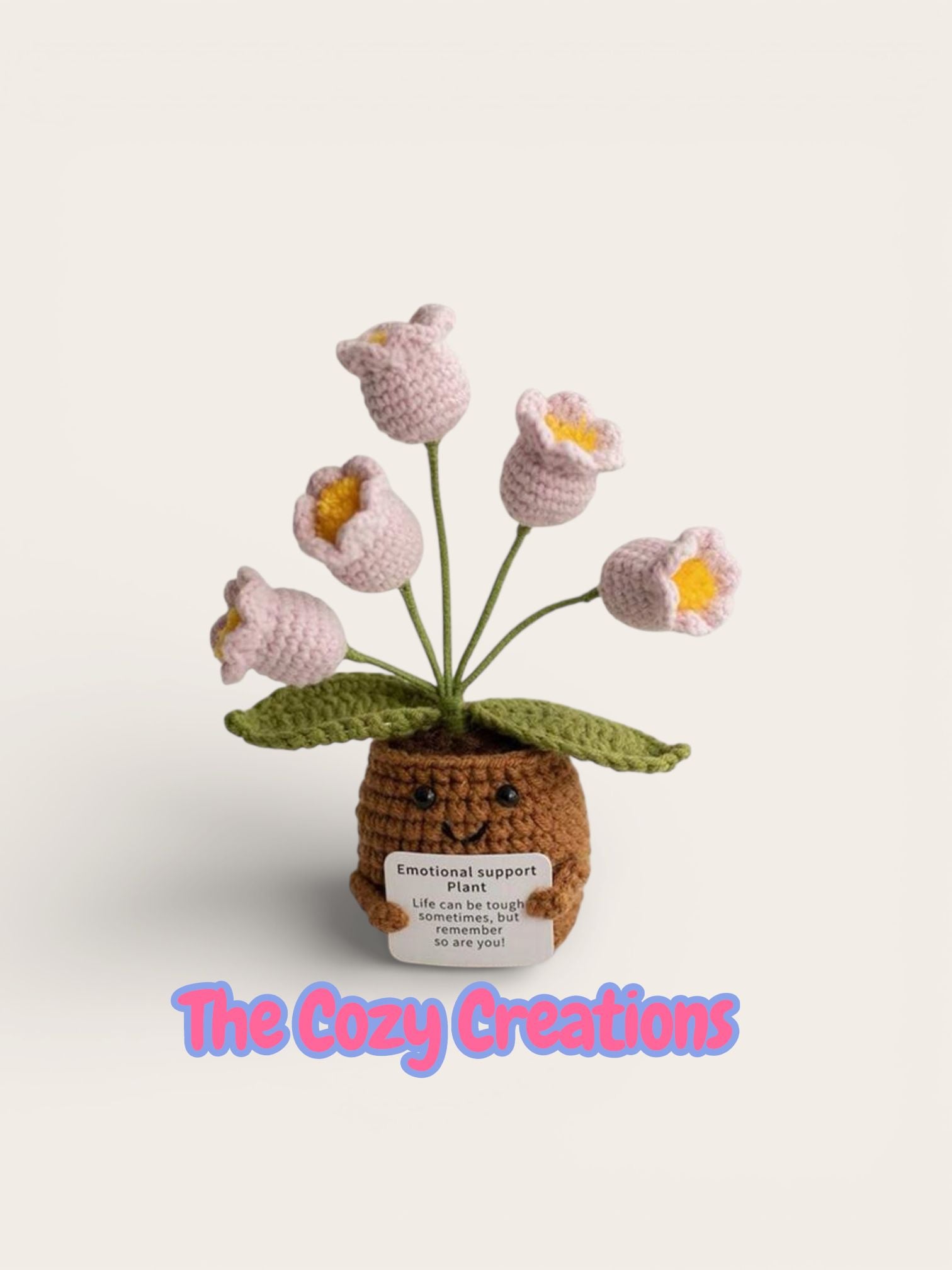 Crocheted flower pot with flowers on a white background, featuring 'The Cozy Creations' brand.