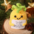 Crocheted pineapple with a sign saying 'Fine-Apple It's fine. you're fine.