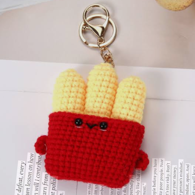 Crocheted keychain with a red bag and yellow corn on a white background