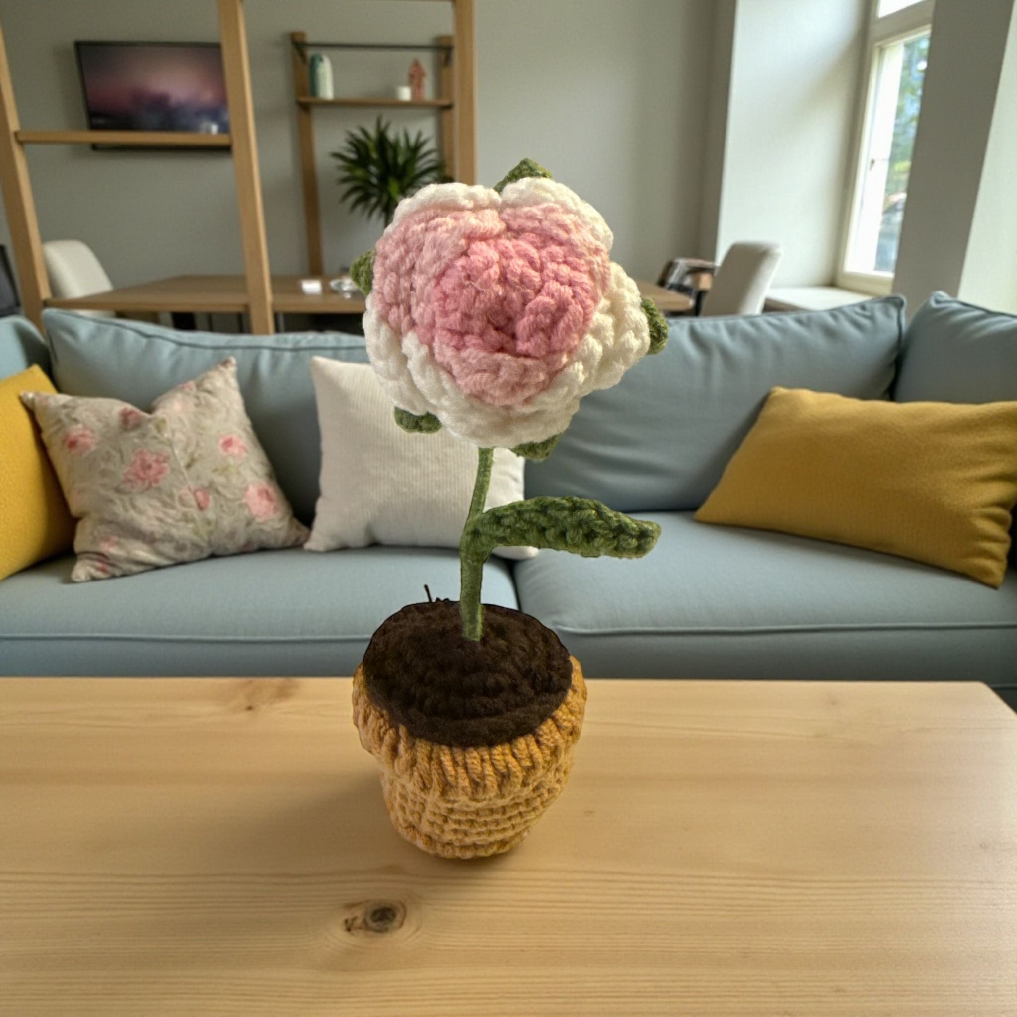 Crocheted flower on a wooden table with a living room background