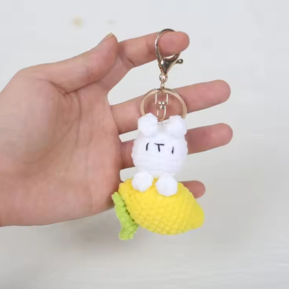 White plush keychain with a lemon on a plain background