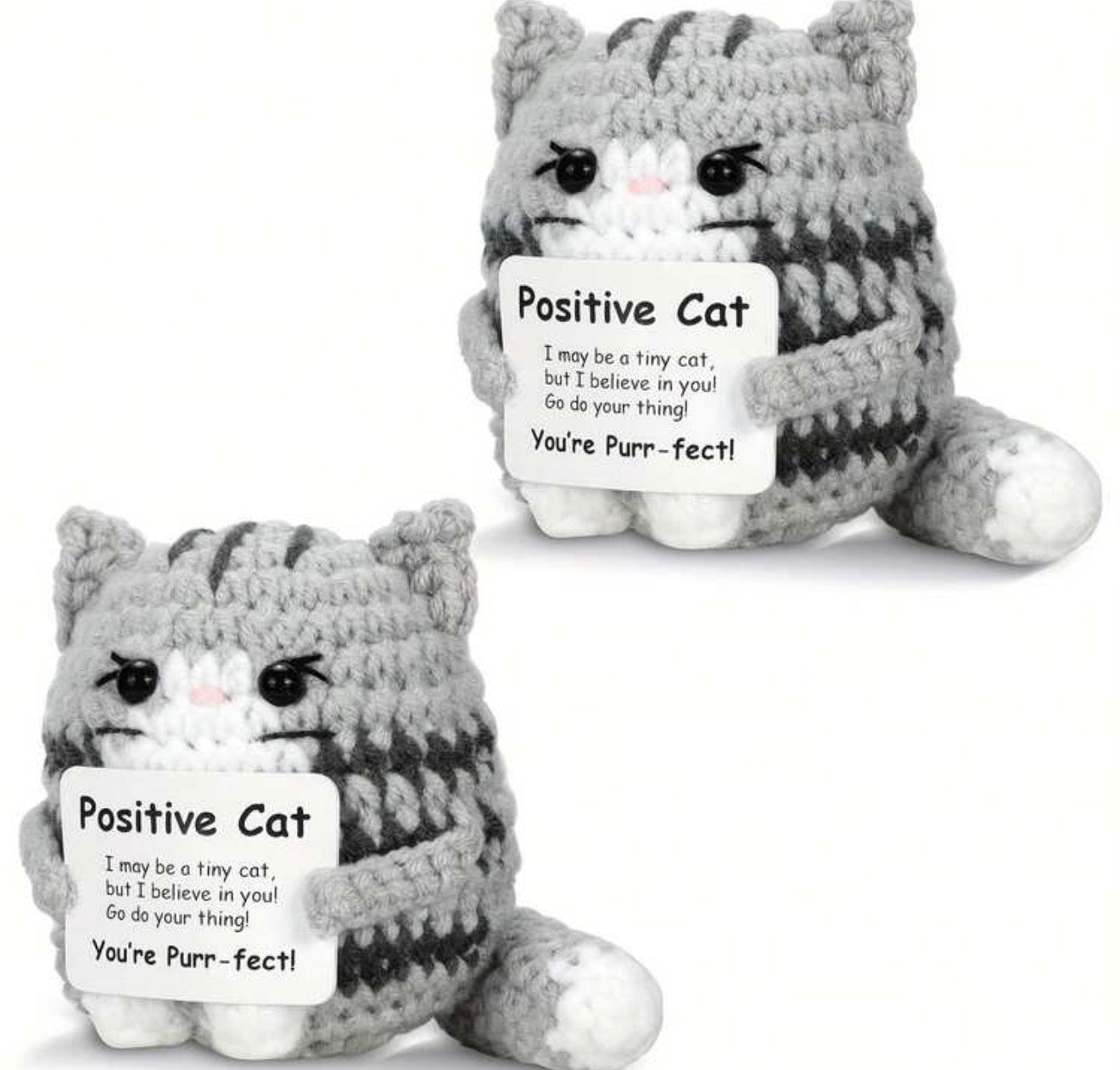 Two gray and white plush cat toys with a message tag on a white background