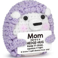Plush hedgehog toy with a purple sweater holding a card that reads 'Mom, here's a hedge-hug...'