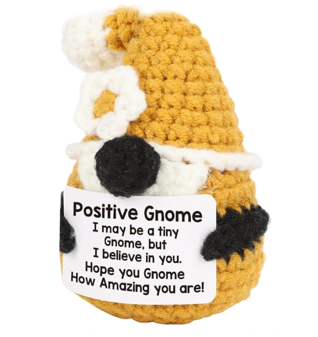 Crocheted gnome with a sign reading 'Positive Gnome' on a white background