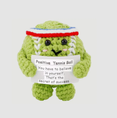 Green plush toy resembling a tennis ball with a message holder on a white background