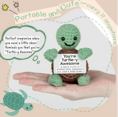 Small green turtle plush toy held in a hand with text on a decorative background