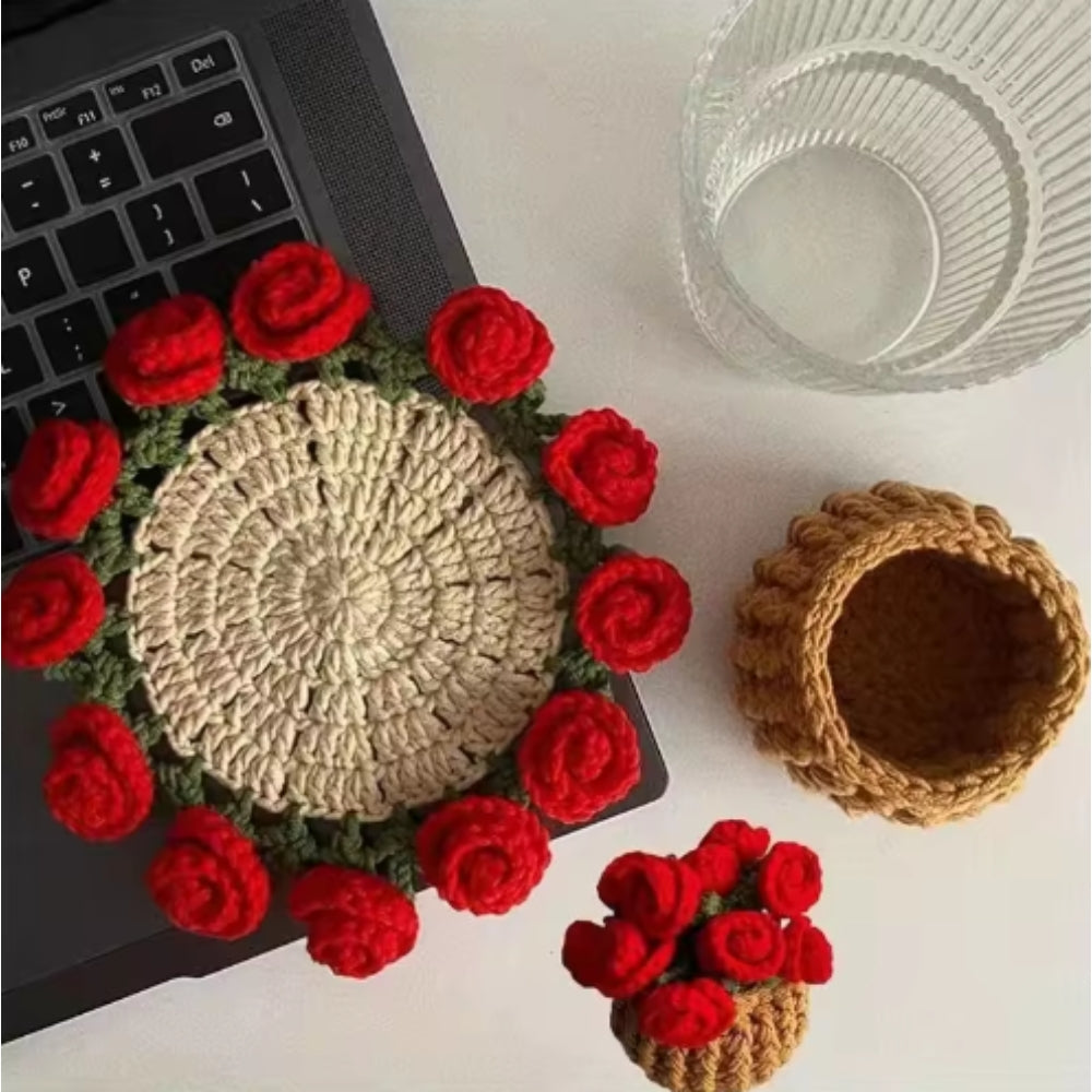 Crocheted items with red flower decorations on a laptop and surface.